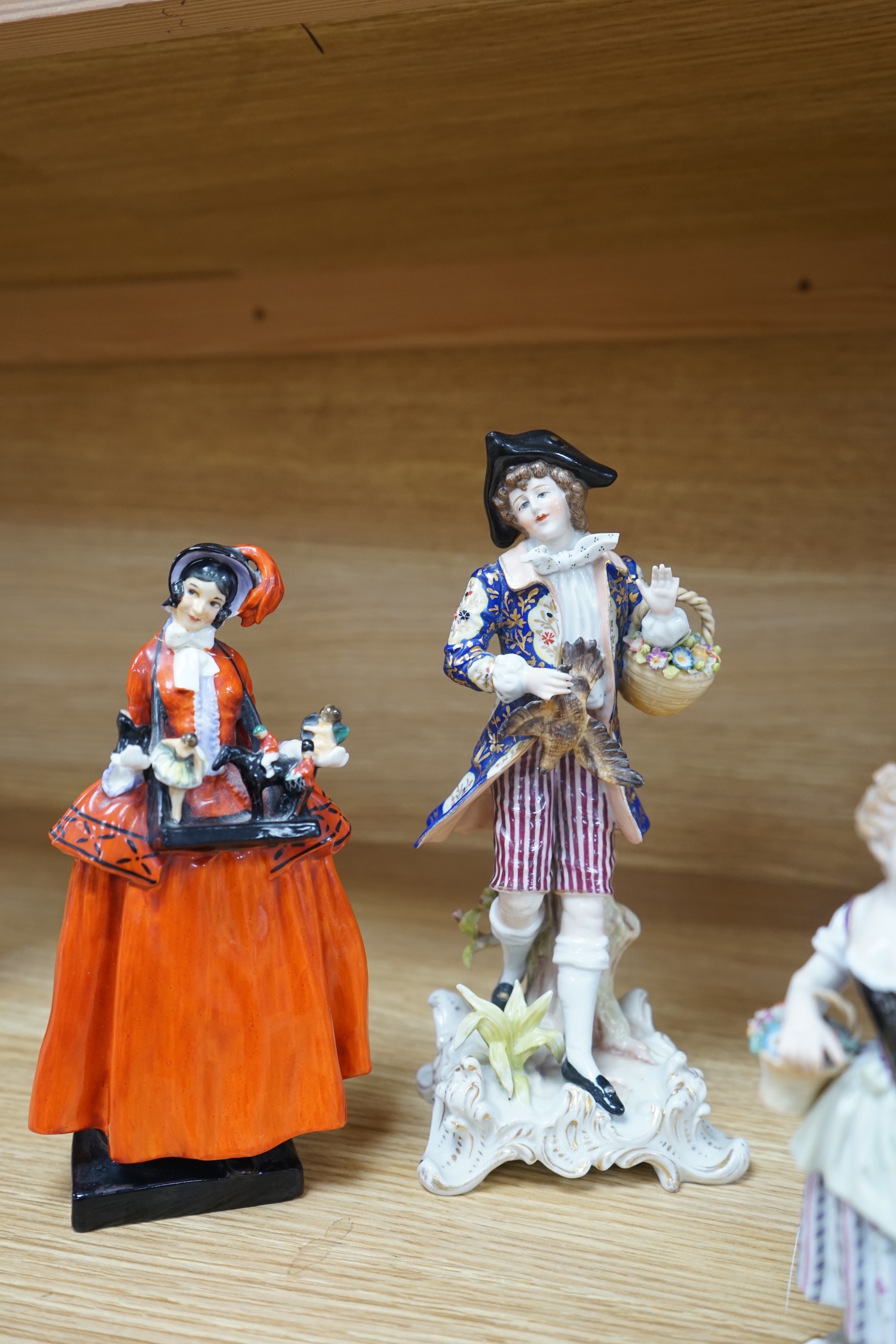 Eight Royal Doulton and 19th century German figures, including two Sitzendorf frog musicians, a Royal Doulton Celia (HN1727) and the toy seller. Condition - fair to good, substantial cracks and damage to the Celia figure